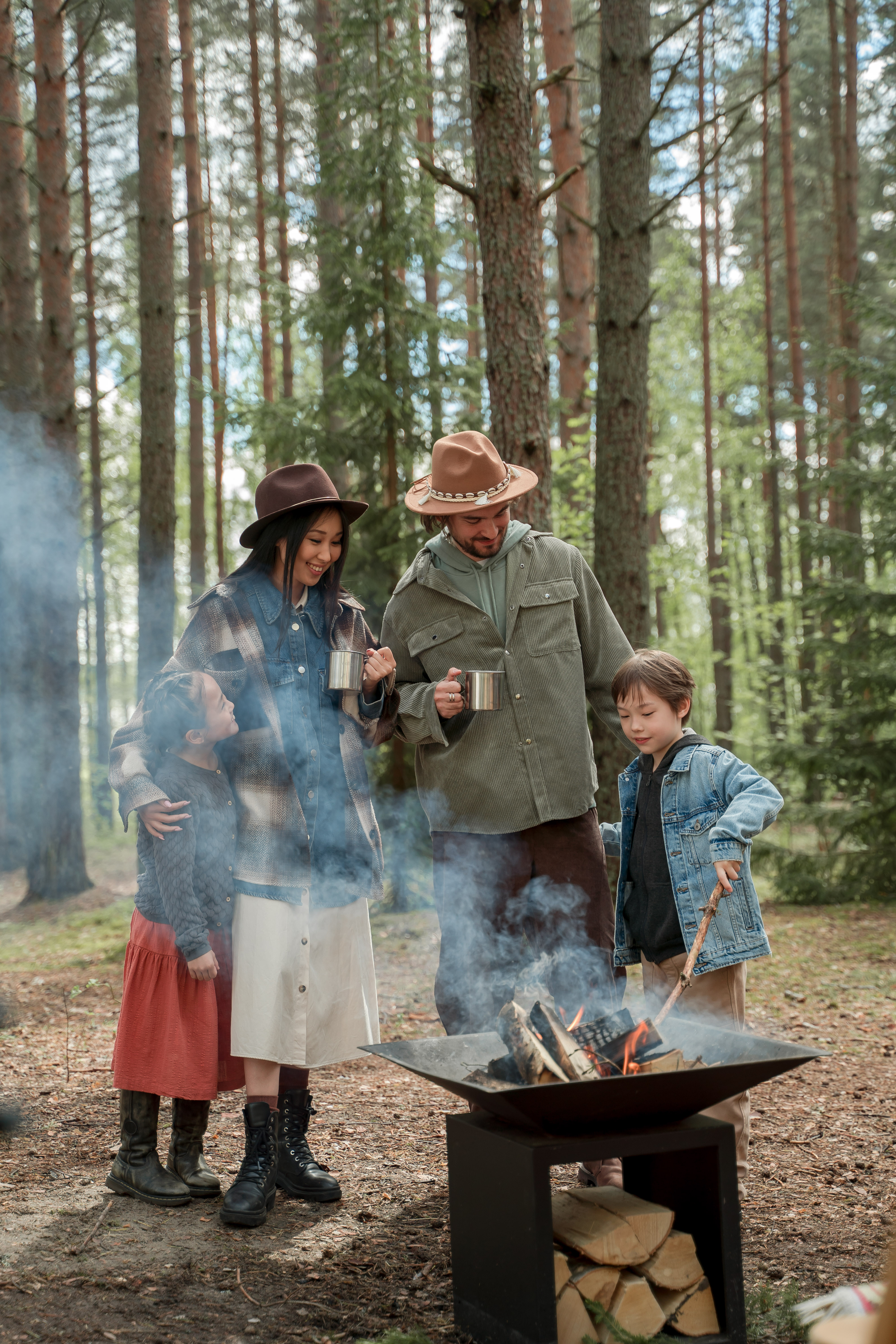 Free A Happy Family Standing by a Firepit in the Woods Stock Photo